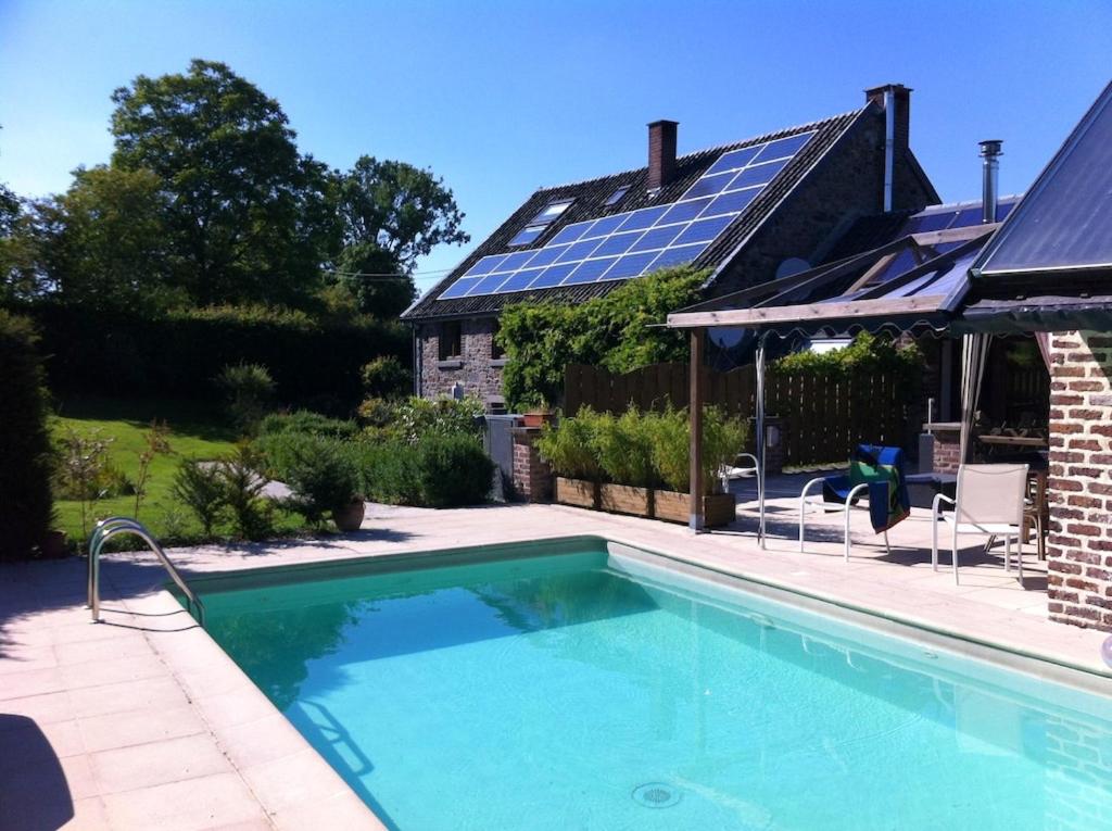 - une piscine en face d'une maison dotée de panneaux solaires dans l'établissement Charming House in Theux with Private Pool, à Theux
