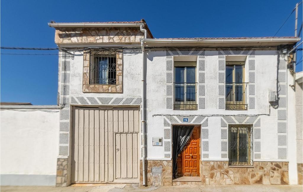 ein altes Haus mit zwei Türen und einem Tor in der Unterkunft 5 Bedroom Stunning Home In Villarrn De Campos in Villarrín de Campos