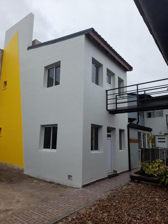 una casa blanca de color amarillo y blanco en Monoambiente Claro de Luz en Federación