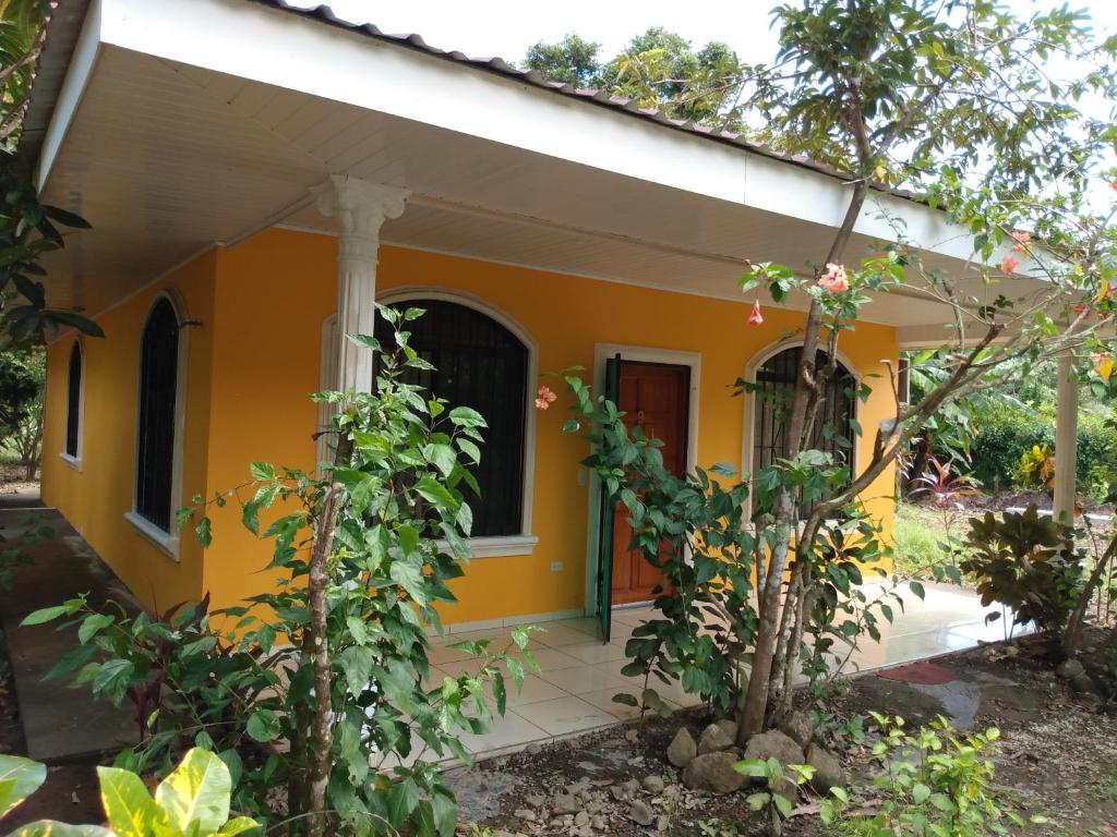 a small yellow house with a porch at Casa Esmeralda in Paquera