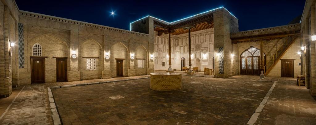 a large building with a courtyard at night at New Star Boutique hotel - madrasah Muhammad Mahram 1903 in Khiva