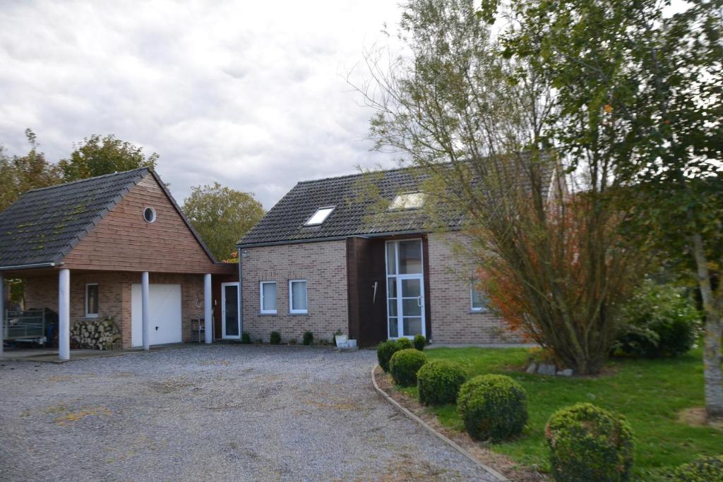 una casa de ladrillo con una entrada delante de ella en Le grand marronnier, en Neuville