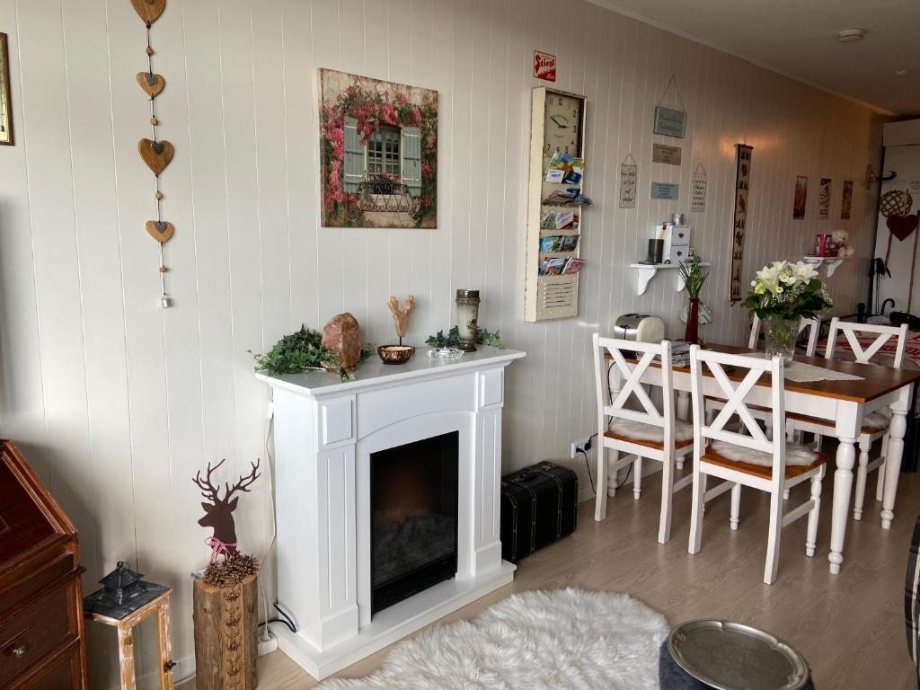 a living room with a fireplace and a dining room table at Appartement Hüttenzauber in Sankt Englmar in Sankt Englmar