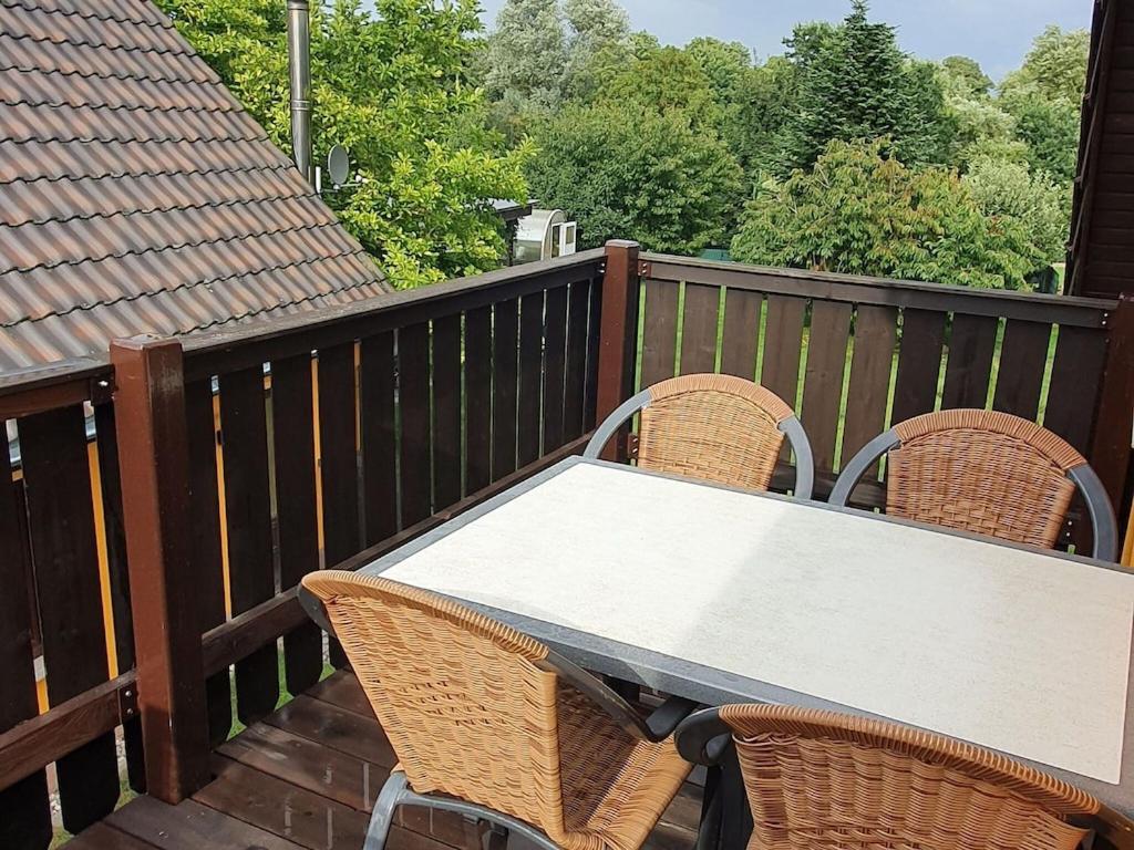 a table and chairs on a deck with a view of trees at Modern Apartment in Zweedorf with Private Garden and Terrace in Zweedorf