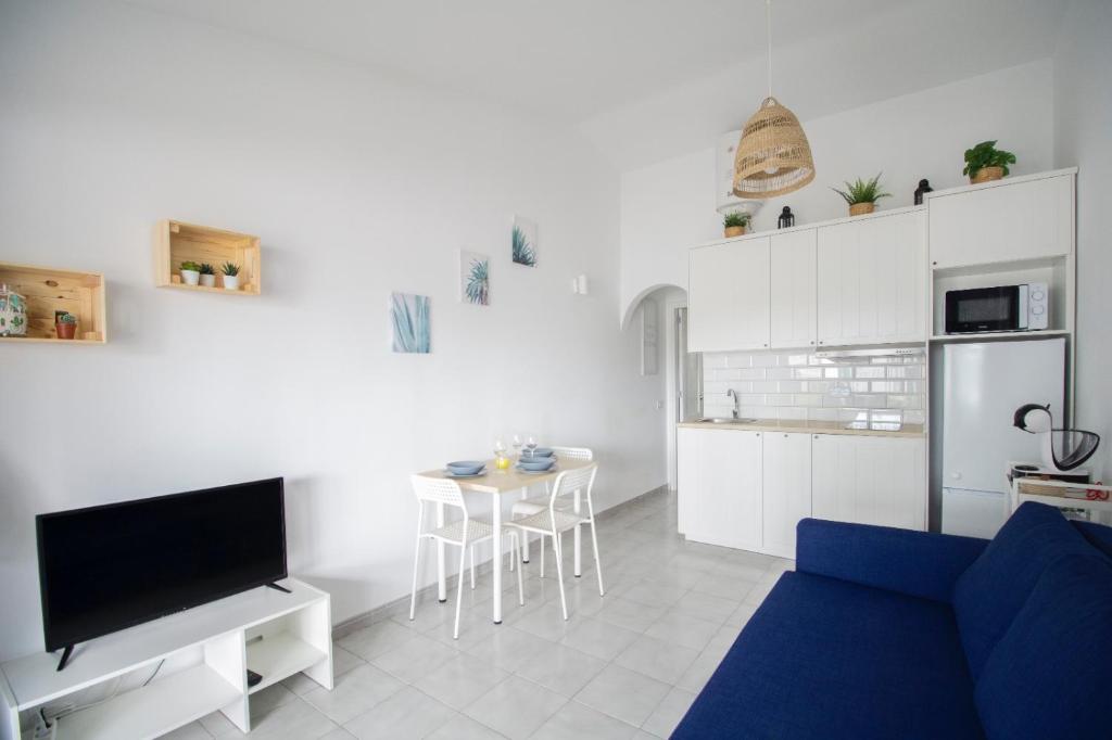 a living room with a blue couch and a kitchen at El Nidito in Maspalomas