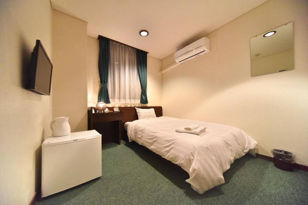 pokój hotelowy z łóżkiem i telewizorem w obiekcie Hotel Nomad - Vacation STAY 71182v w mieście Hitachi