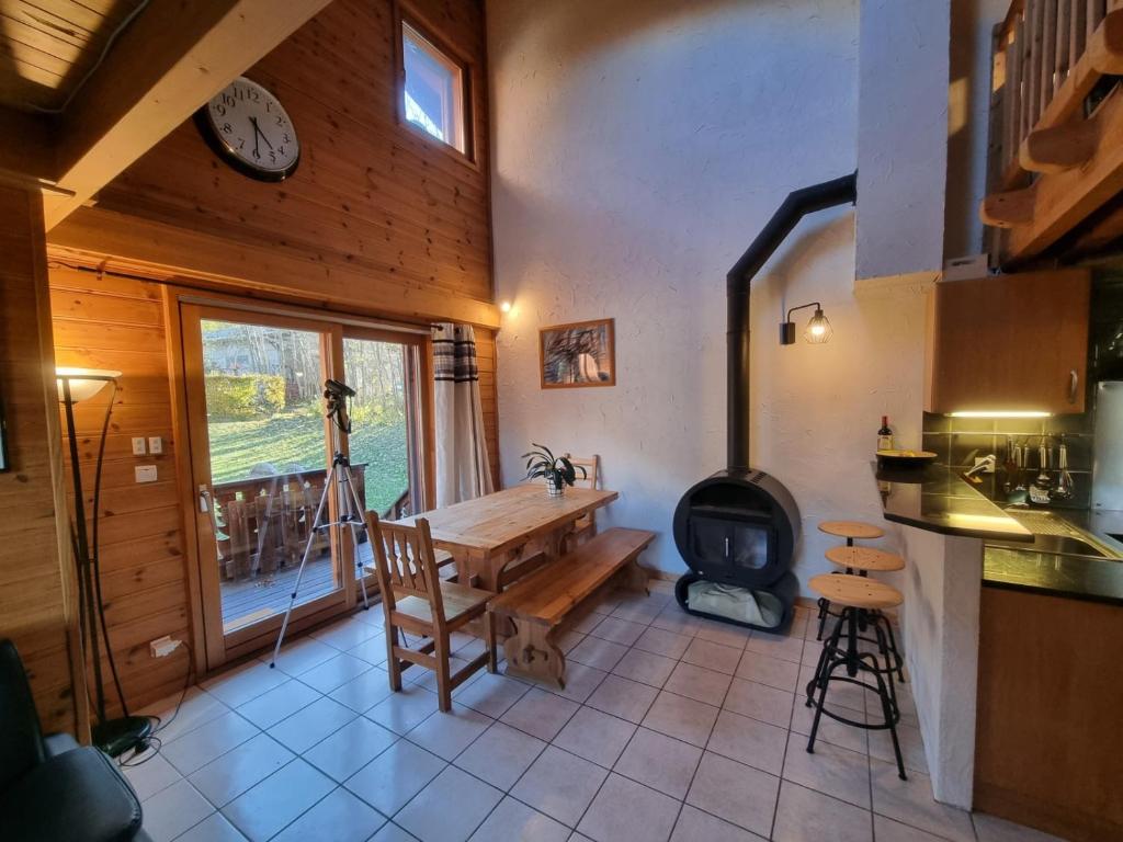 cocina con mesa y estufa de leña en Chalet Tontine, 3 bedrooms, sauna, terrace and great views !, en Les Houches