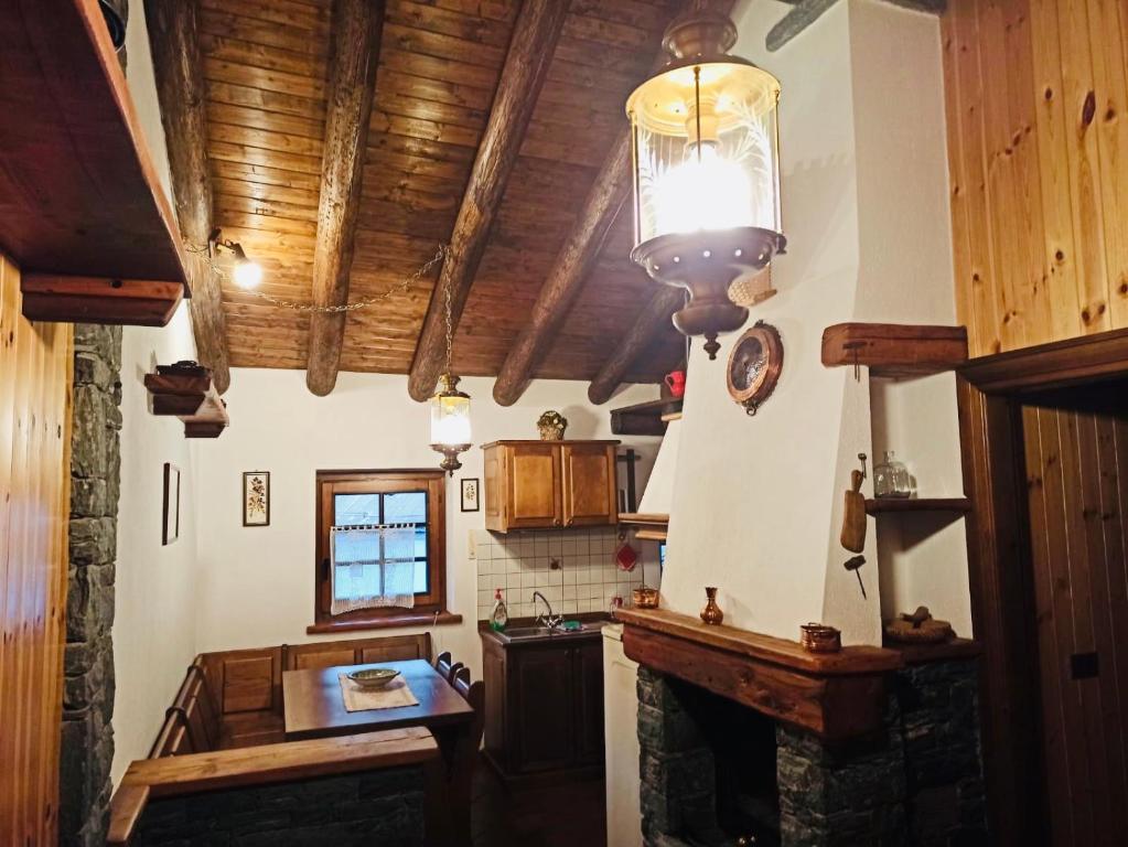 una cucina con soffitti in legno e un tavolo in una camera di Maison Vollon a Brusson
