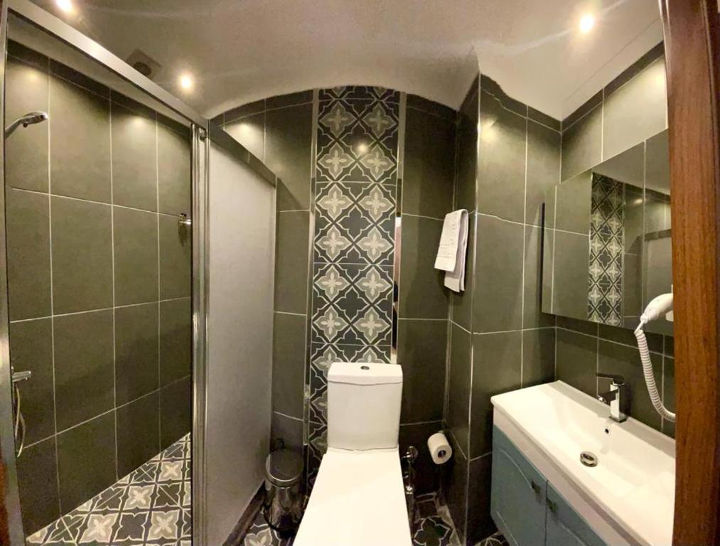 een badkamer met een toilet, een douche en een wastafel bij ÜSKÜDAR OTEL in Istanbul