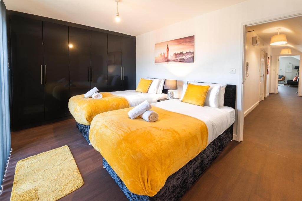two beds in a hotel room with yellow sheets at Perfect For Business And Leisure- Free Parking in Southampton
