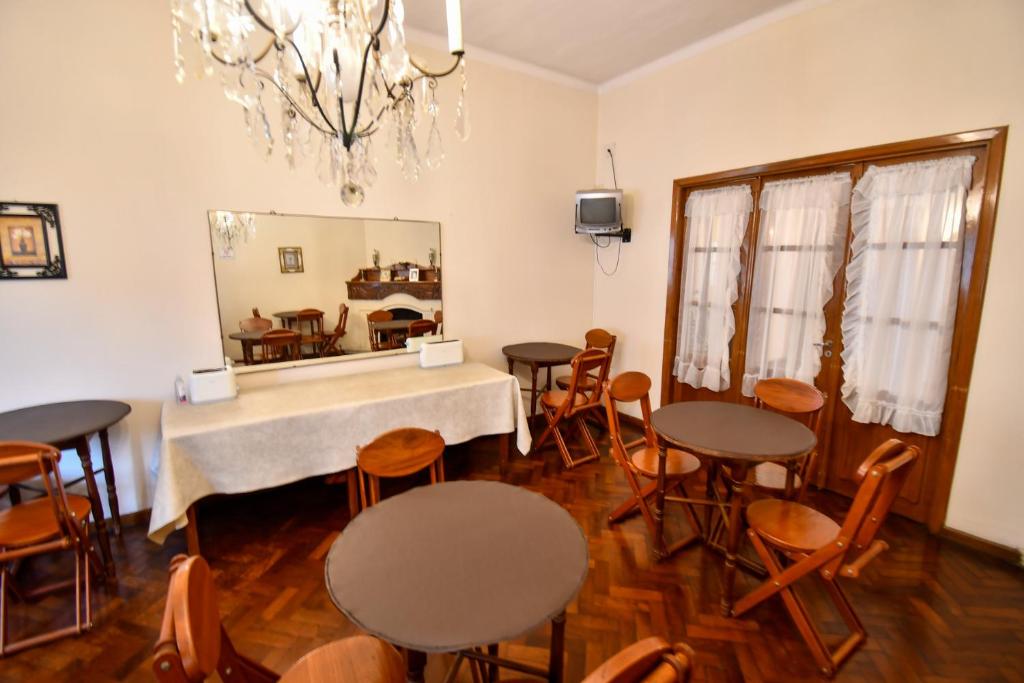 comedor con mesas, sillas y espejo en Hostal El Cerrito en Salta