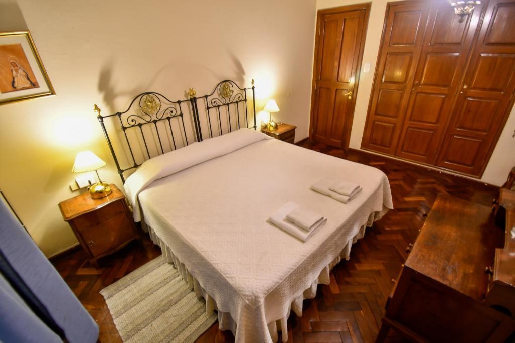 a large bed in a room with two night stands at Hostal El Cerrito in Salta