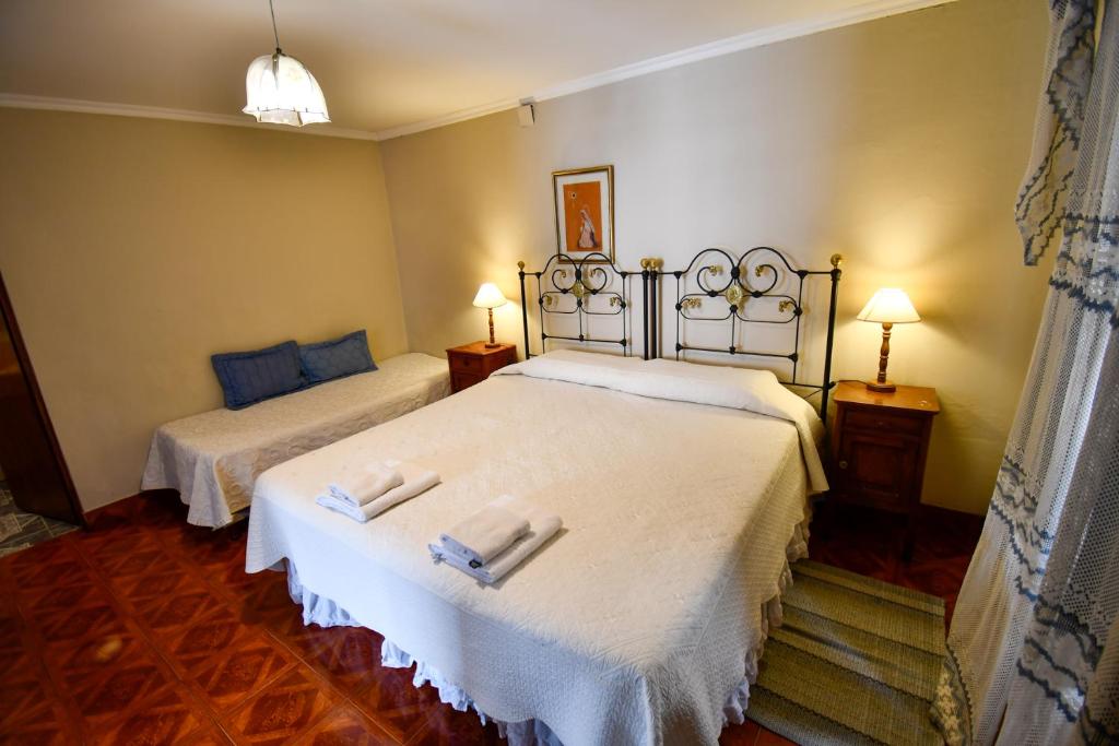 a bedroom with two beds with white sheets at Hostal El Cerrito in Salta