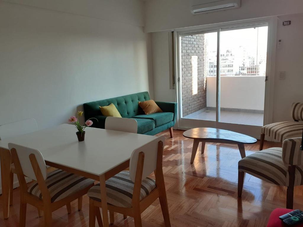 sala de estar con mesa, sillas y sofá en Barracas 3 ambientes en Buenos Aires