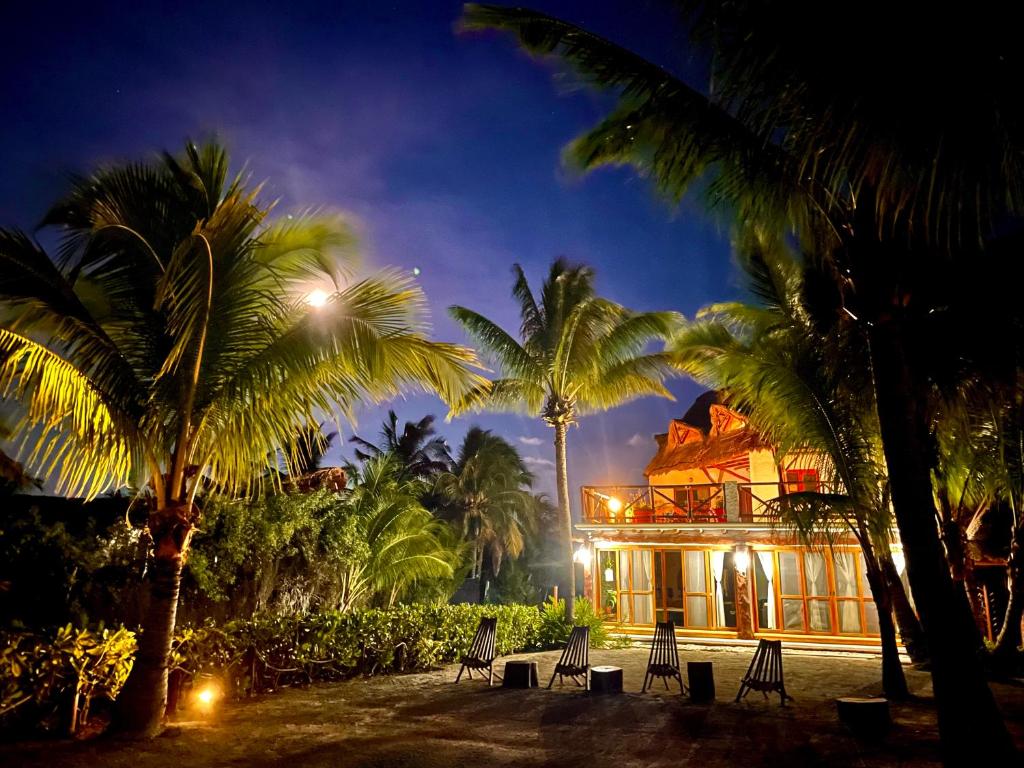 a building with palm trees in front of it at Casa Luz Beach Front Holbox in Holbox Island