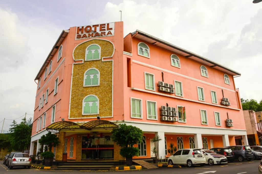a hotel lahaina building with cars parked in a parking lot at HOTEL SAHARA SDN BHD in Rawang