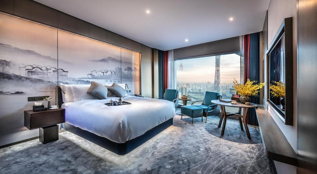 una camera d'albergo con letto, tavolo e sedie di Guangzhou Elegant Hotel a Canton
