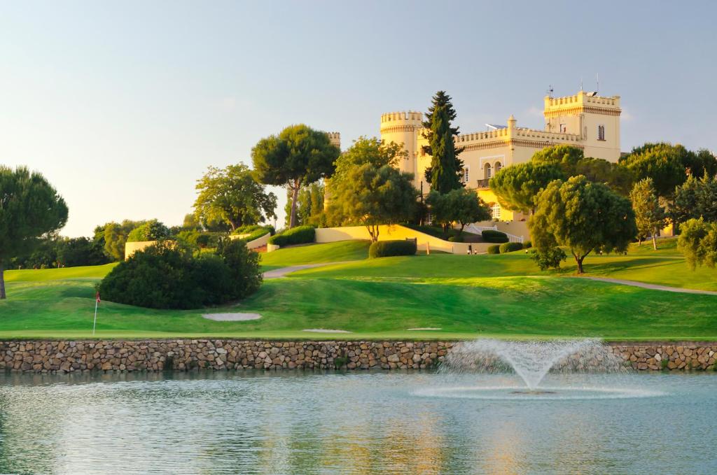 un campo de golf con un estanque y un edificio en Barceló Montecastillo Golf en Jerez de la Frontera