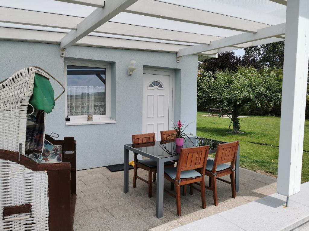 Bungalow 4 Pers. في Elmenhorst: فناء تحت طاولة وكراسي