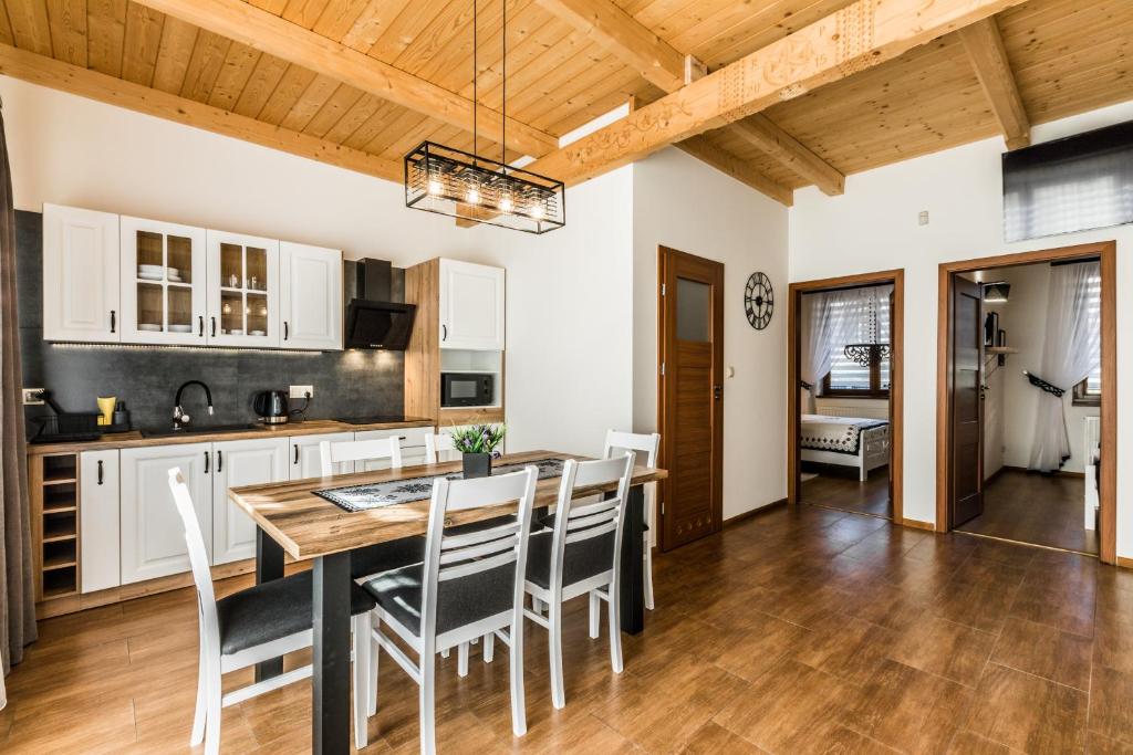 a kitchen with a dining room table and chairs at Apartamenty Harenda Ski in Zakopane