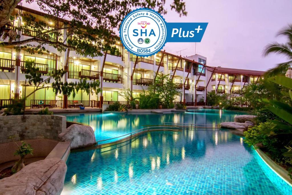 a swimming pool in front of a building at The Elements Krabi Resort - SHA Plus in Klong Muang Beach