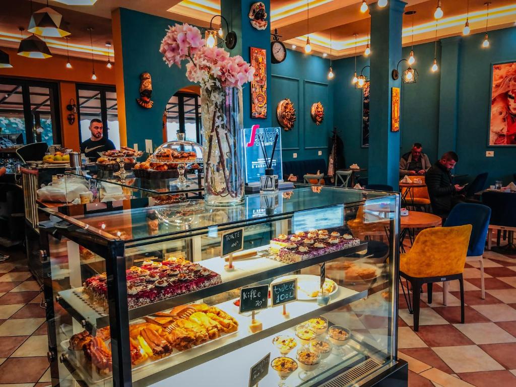 una panadería con una vitrina llena de pasteles en Promenade Hotel, en Shkodër