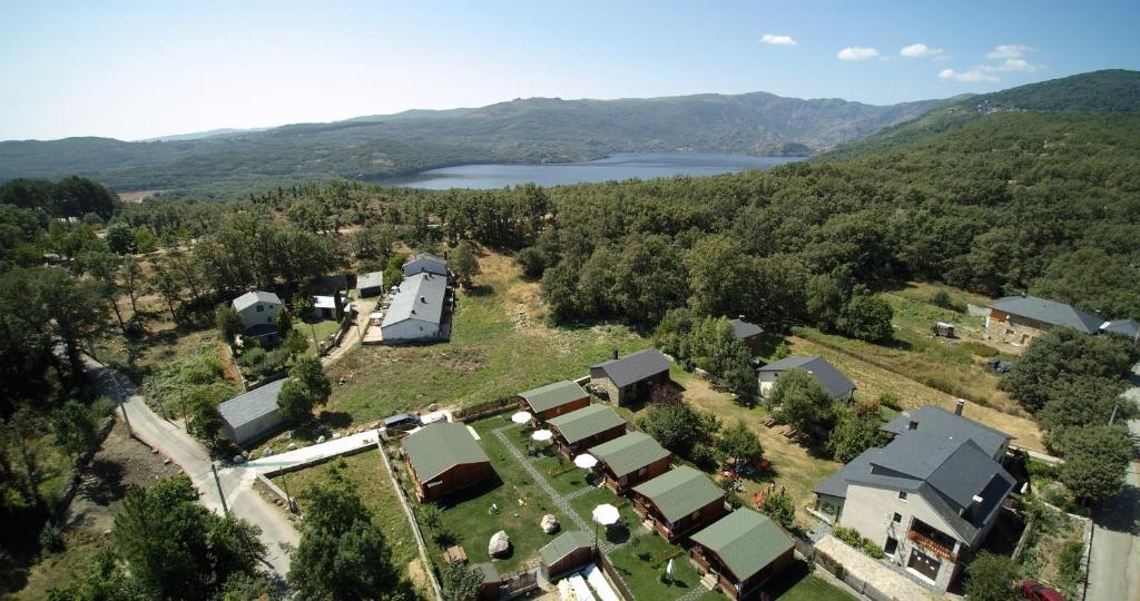 an aerial view of a house with a lake at Cabañas Madarsu in Vigo de Sanabria