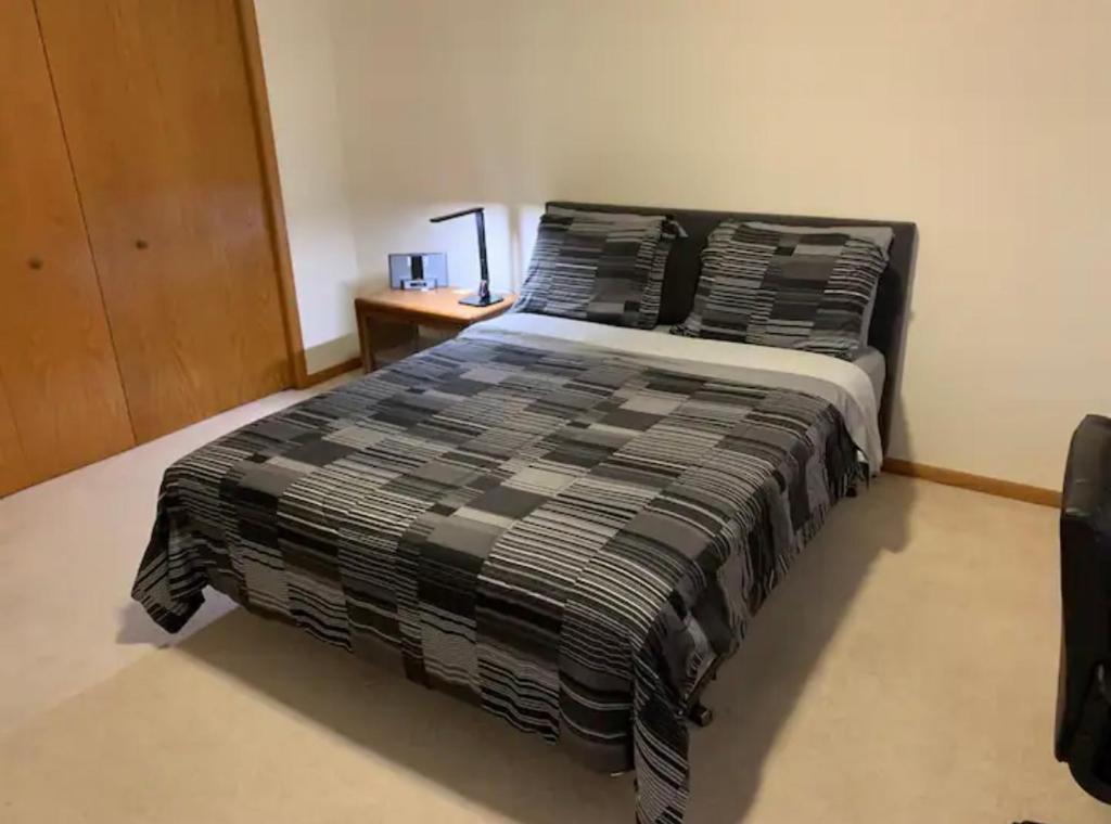 a bedroom with a bed and a desk with a lamp at Room Near IL State Capitol in Springfield