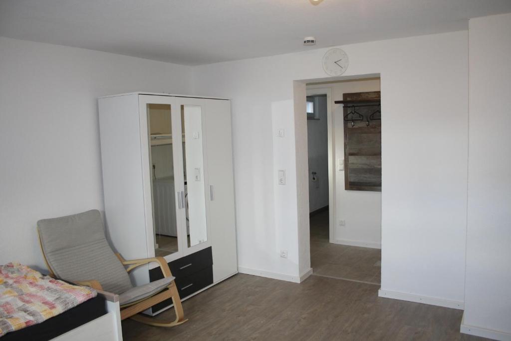 a bedroom with a chair and a bed and a mirror at Schönes Zimmer mit Bad für Reisende in Murg