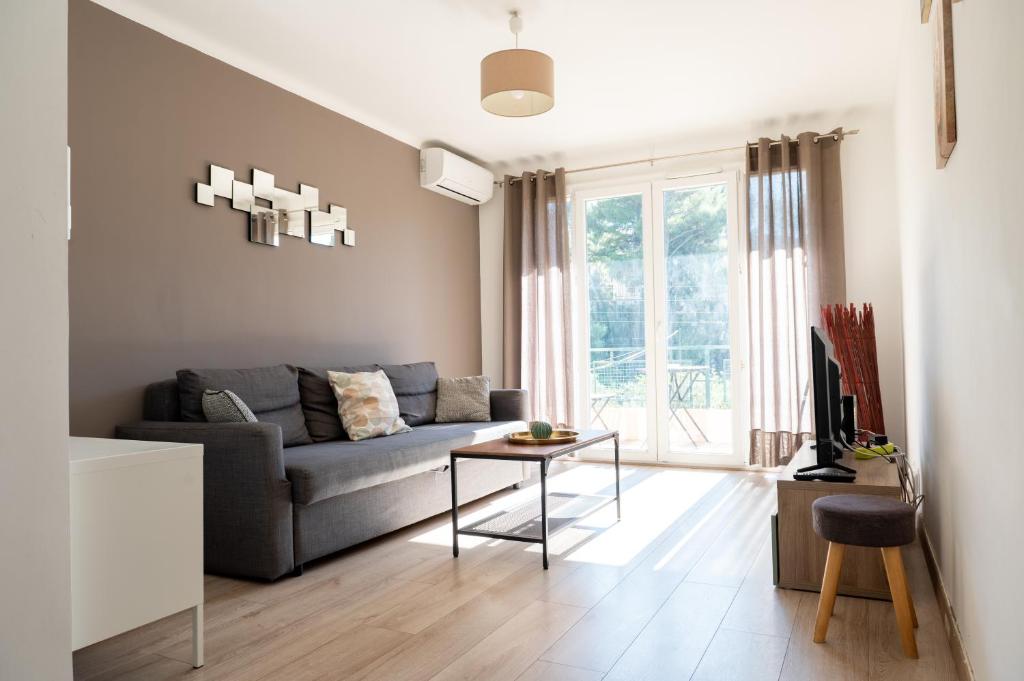 a living room with a couch and a table at Résidence La Source in Toulon