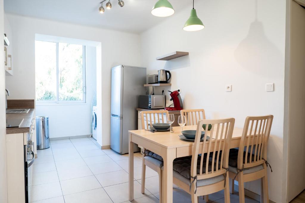 a kitchen with a table and chairs and a refrigerator at Résidence La Source in Toulon