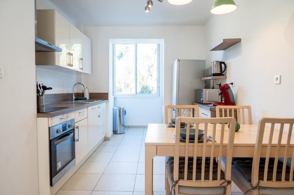 a kitchen with a table and a dining room at Résidence La Source in Toulon