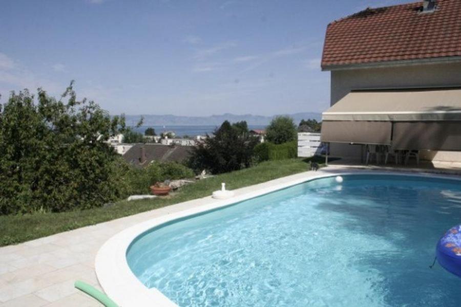 a swimming pool in front of a house at Entre Alpes et Léman in Publier