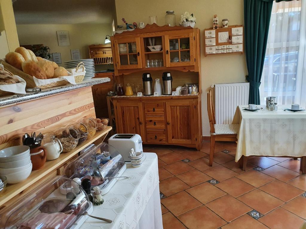 una cucina con tavolo e pane e tavolo con sidro. di Bozi Rozi Panzió a Fertőboz