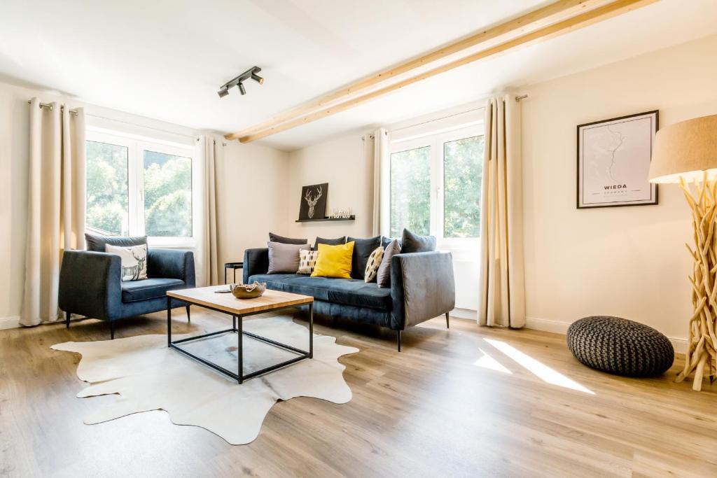 uma sala de estar com um sofá e uma mesa em Harzfalke Apartment - Ankommen und wohlfühlen. em Wieda
