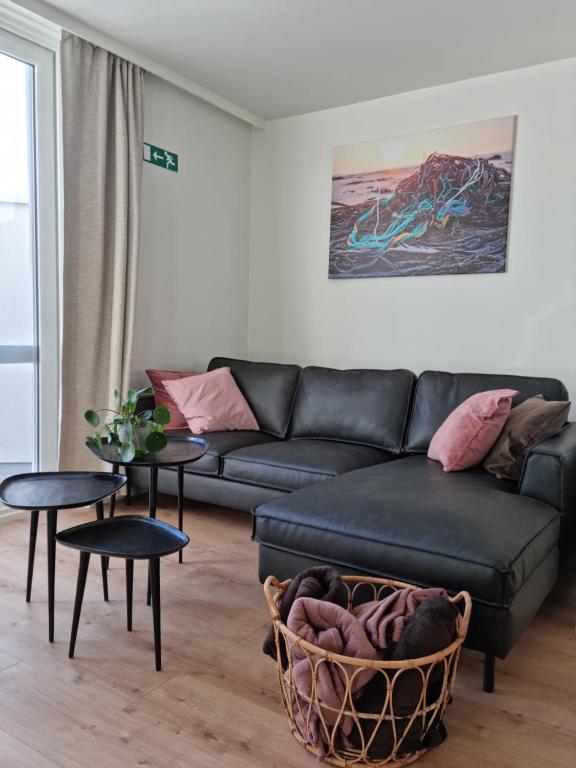 a living room with a black couch and a table at Maison Florimond in Nieuwpoort