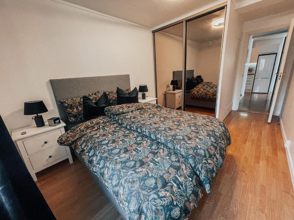 um quarto com uma cama grande e um espelho grande em Apartment with 2bedrooms near the train and buss station em Moss