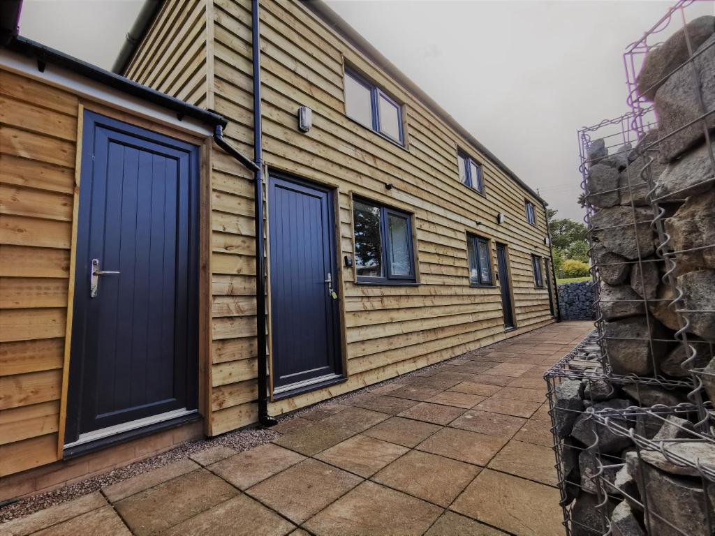 a house with two blue doors on the side of it at The Trotting Mare Caravan Park - Adults Only in Wrexham