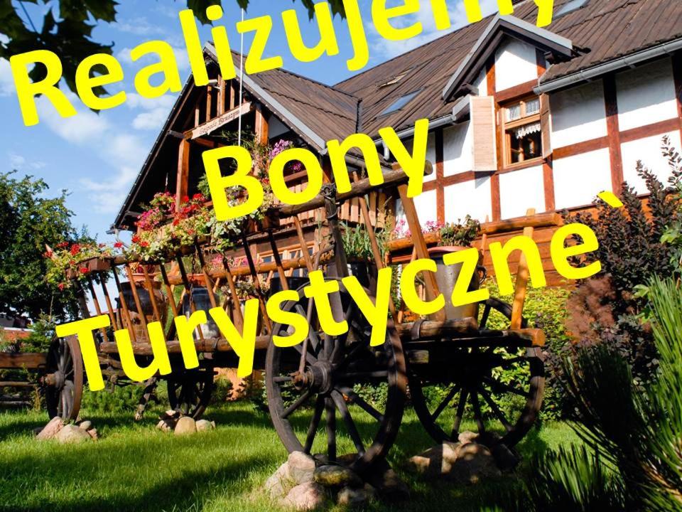 una casa con una carretilla en el patio con las palabras realidad huesuda en Gospoda Kruszyna, en Kruszyn