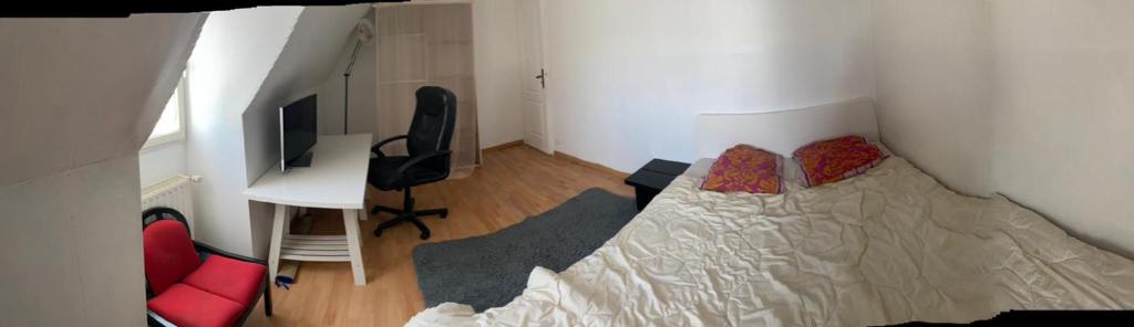 Nandy的住宿－CHAMBRE de LUXE，一间卧室配有一张床、一张书桌和一台电视
