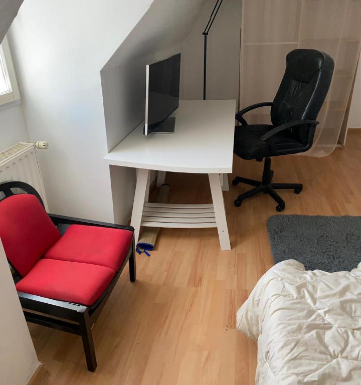- une chambre avec un bureau, une chaise rouge et un lit dans l'établissement CHAMBRE de LUXE, à Nandy