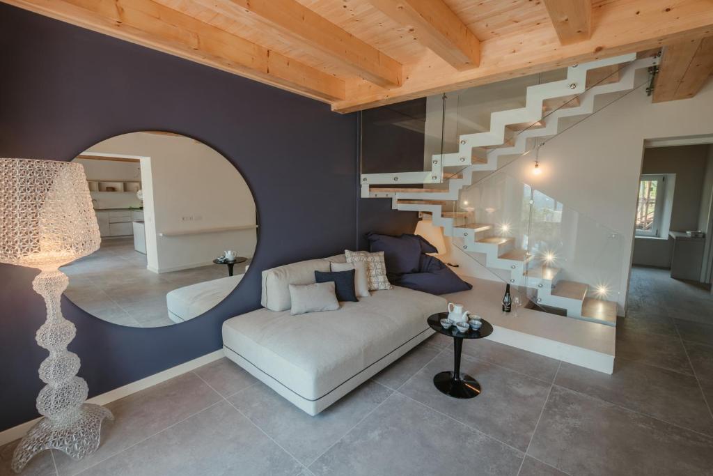 uma sala de estar com um sofá e uma escada em espiral em B&B Casa Dorotei em Cusighe