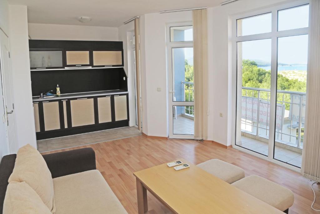 una sala de estar con un sofá y una mesa en Kirovi Apartment, en Primorsko