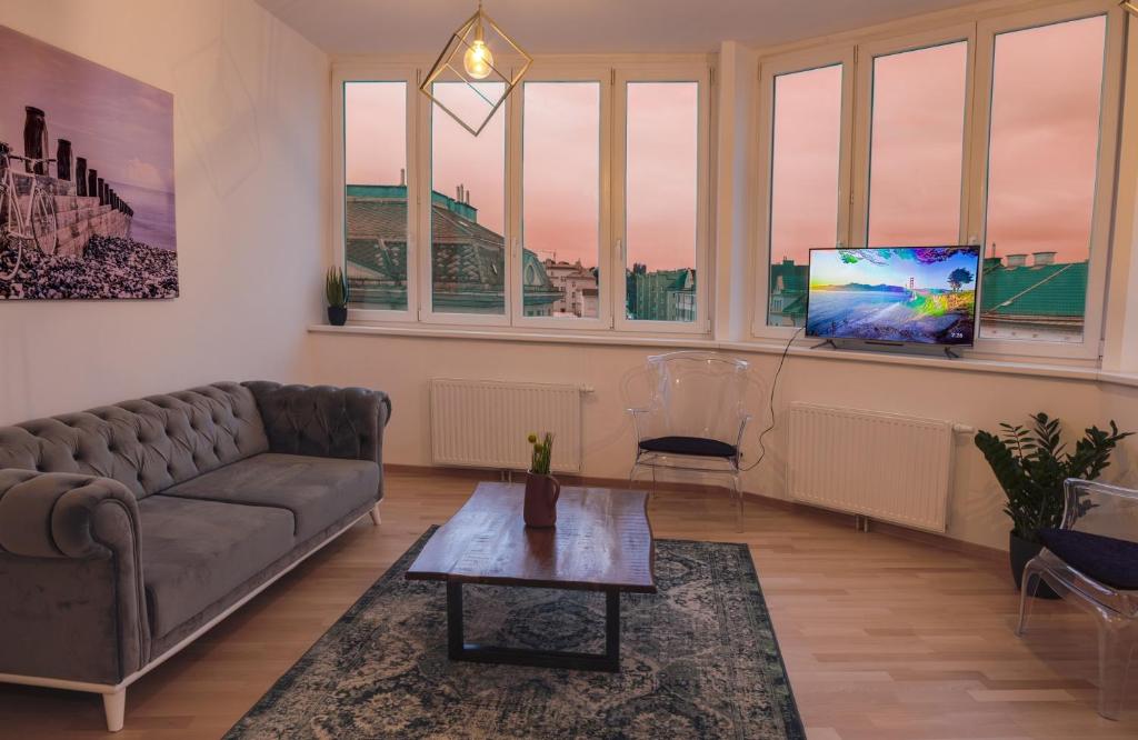 ein Wohnzimmer mit einem Sofa und einem TV in der Unterkunft Gesamte Unterkunft über den Dächern Wiens in Wien