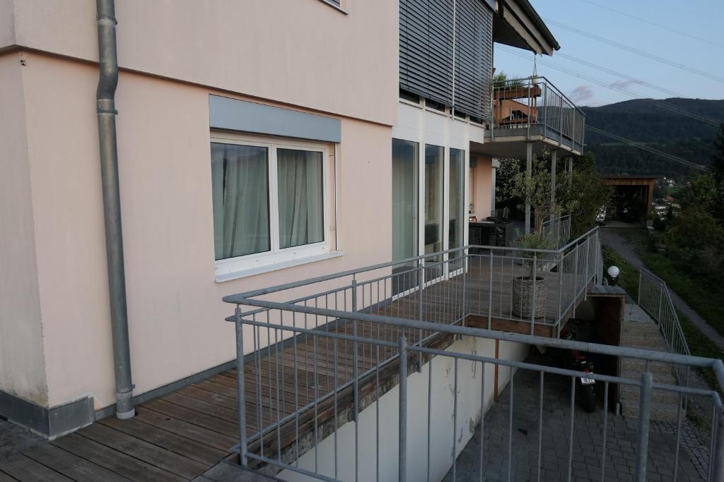 einen Balkon mit einem Geländer neben einem Gebäude in der Unterkunft Ferienwohnung Casa Rosa in Bildstein