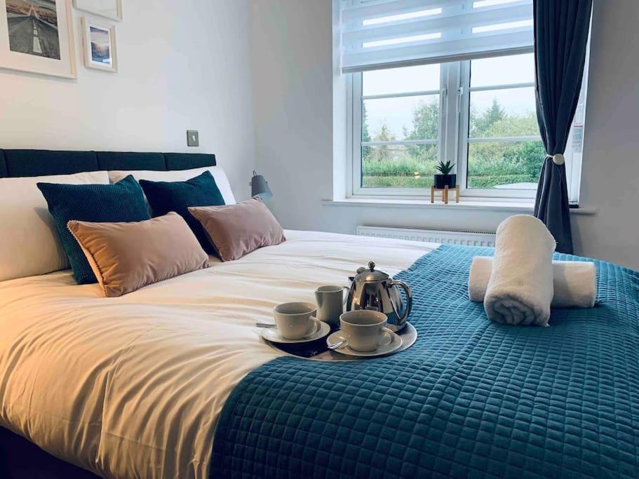 Una cama con una bandeja con un set de té. en Stylish & Spacious 3 Bed House With 2 Free Car Parking Spaces, en Appledram