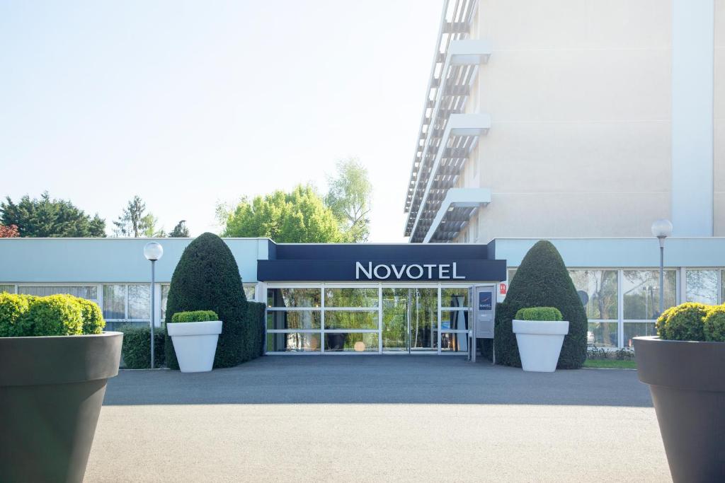un bâtiment avec une enseigne indiquant Novotel dans l'établissement Novotel Poissy Orgeval, à Orgeval