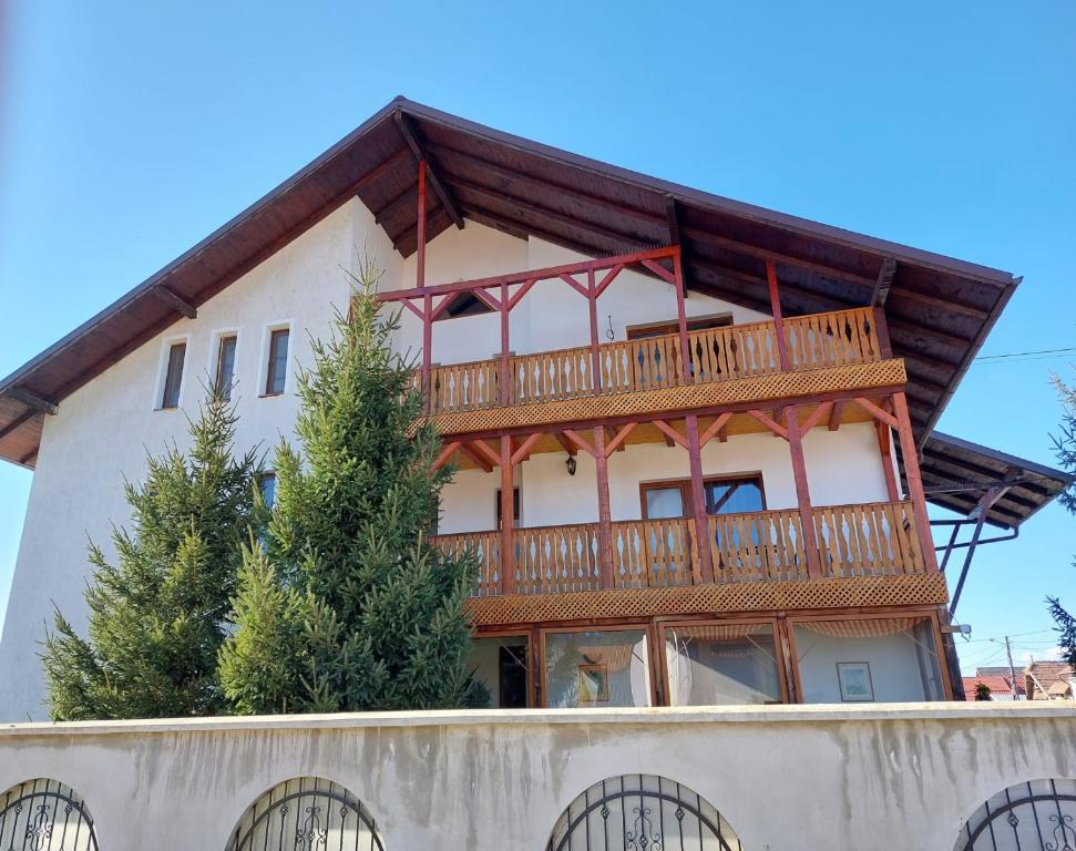 a large house with a deck on top of a wall at Pensiunea Vera in Râşnov