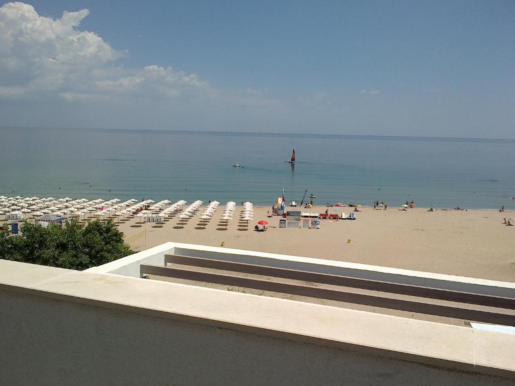 a beach with umbrellas and chairs and the ocean at Azur Apartments in Sozopol