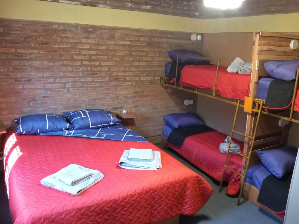 a room with three bunk beds with towels on them at El Gringo Tito in La Falda